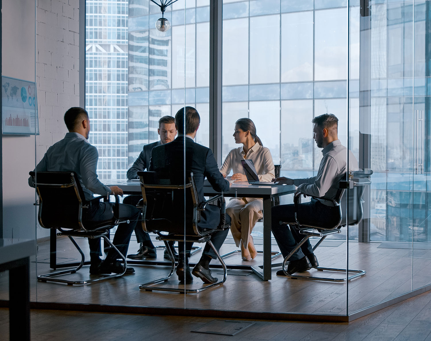 Business team having a meeting in a modern glass-walled conference room with a city skyline view, discussing strategy and collaboration.