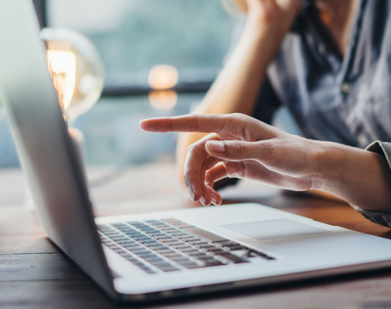 Business people's hands pointing at laptop