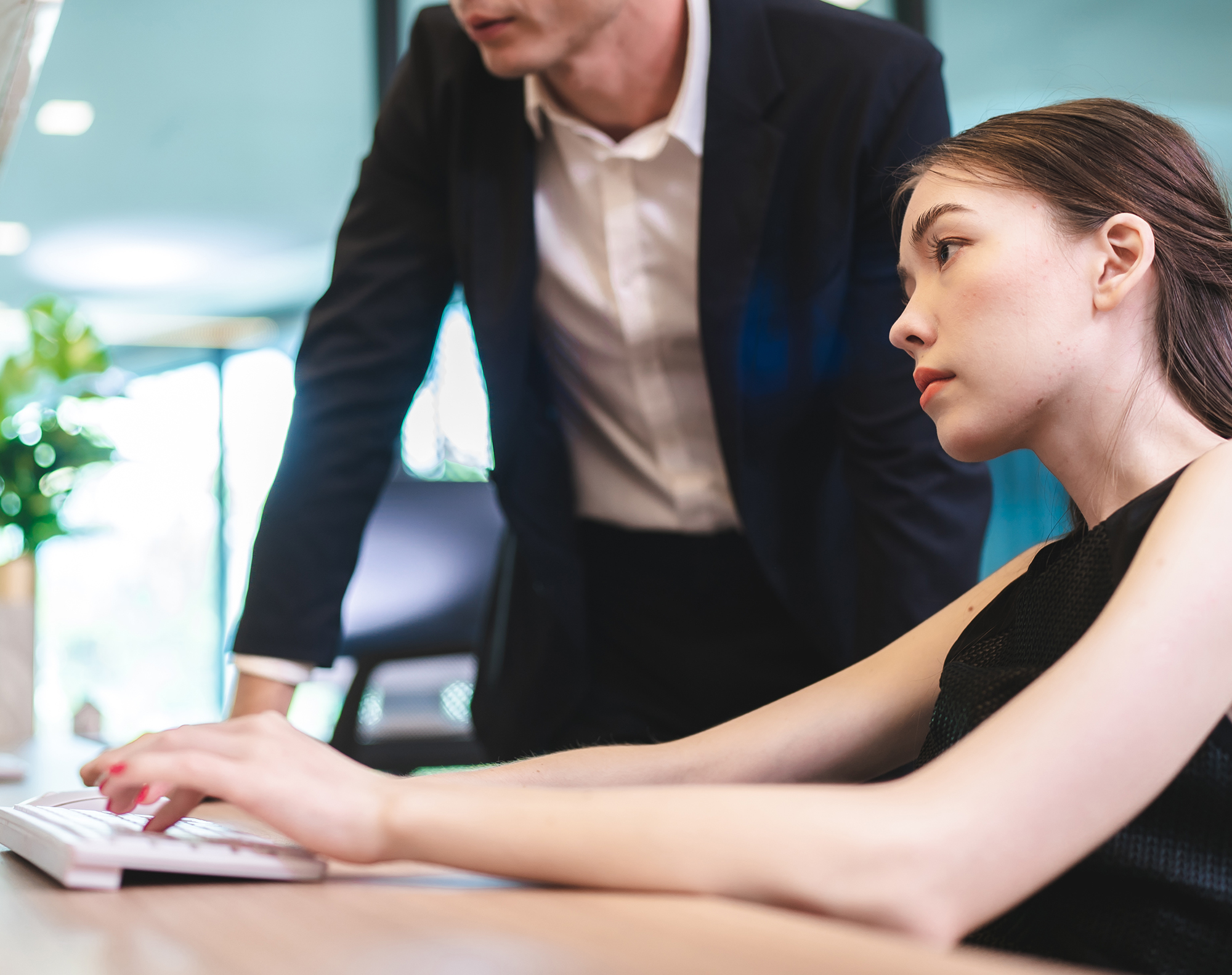 Two business professionals analyzing financial reports with charts and graphs, using sticky notes and a calculator for planning at a collaborative workspace.